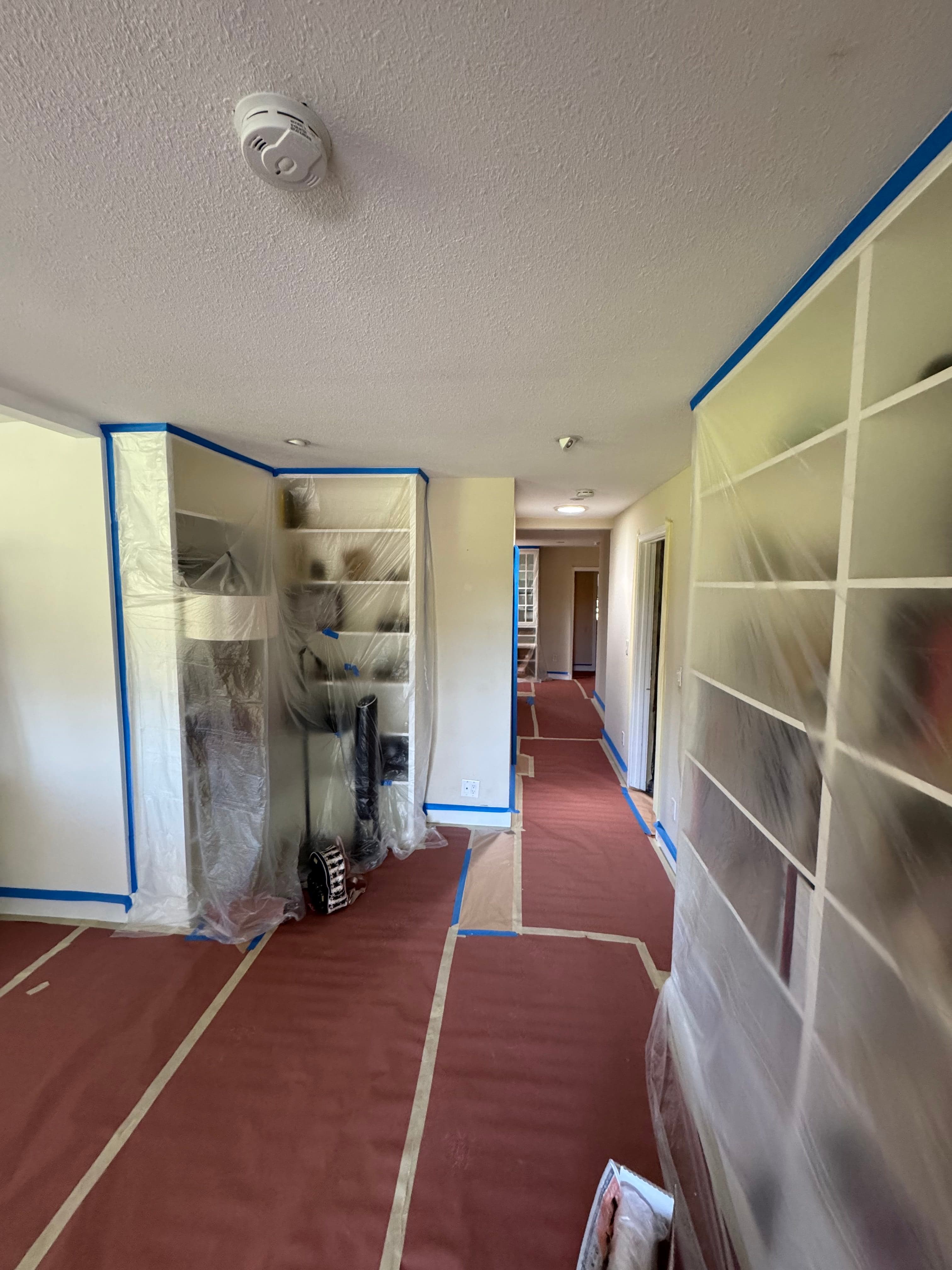 Room prepared with floor and furniture protection before drywall work