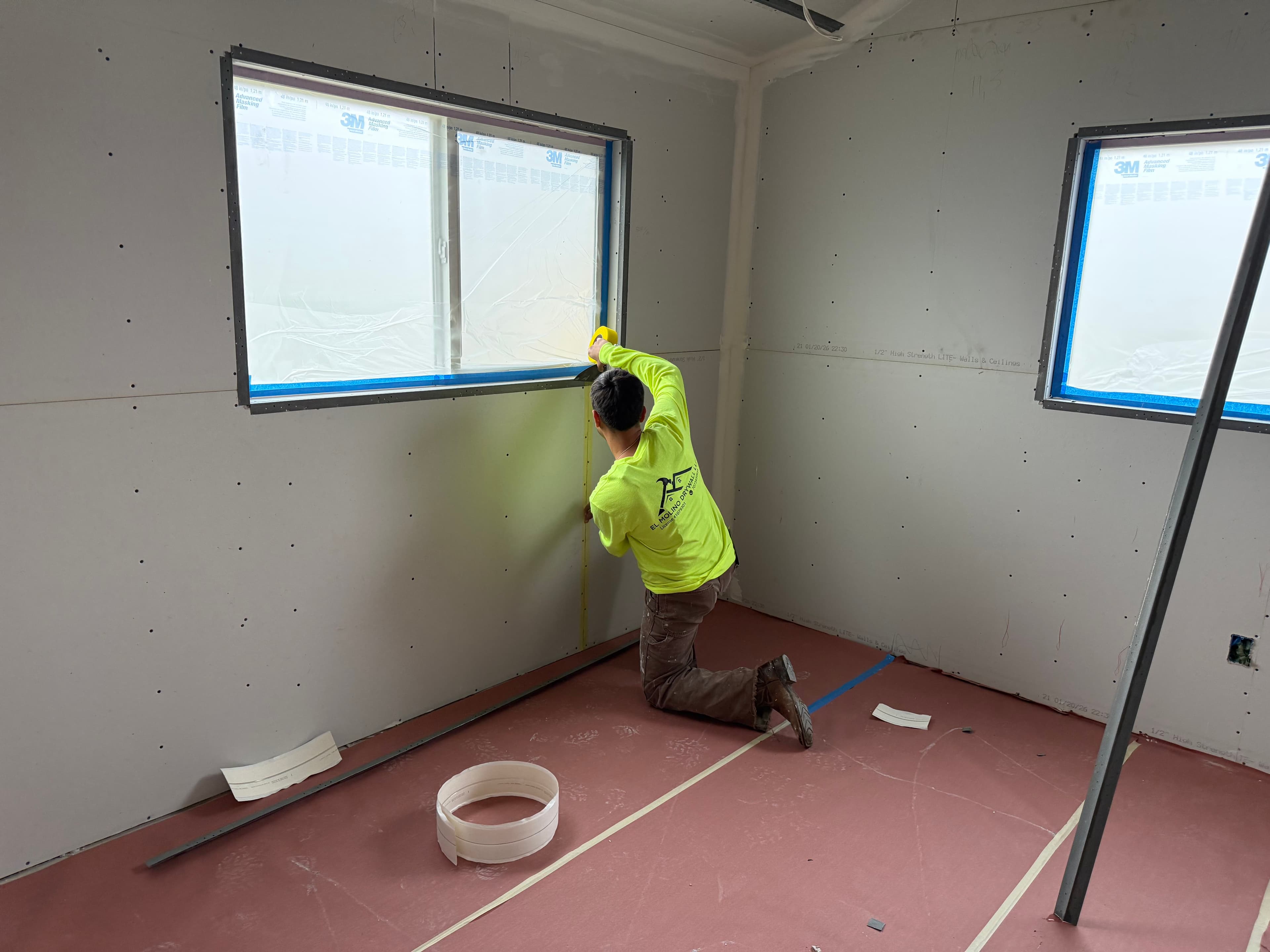 Project manager reviewing drywall scheduling plans